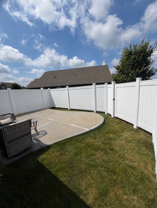 White vinyl privacy fence around a back yard patio