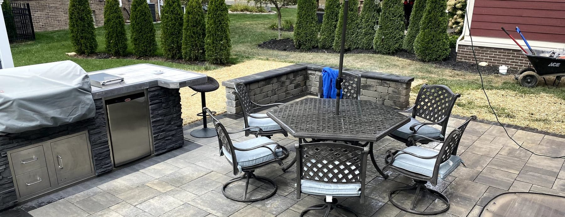 Finished paver patio with an outdoor kitchen and seating